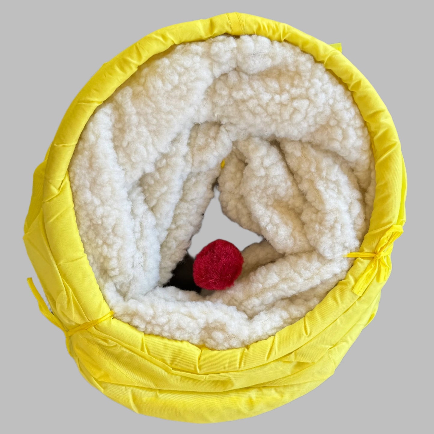 shown here collapsed with closeup to show texture of fleece and bonus faux fur ball