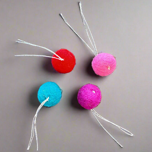 wool balls with thread "tail" are small enough for a cat to pick up with their mouth to carry or toss, just over an inch (2.5 cm) in diameter