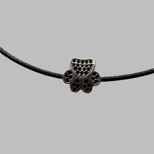 closeup of silver metal paw print bead on waxed cord necklace, purrfect with everything and so cute!