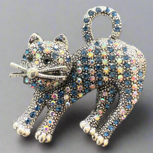 Super cute brooch is a purrrfect accessory for any outfit. Iridescent rhinestones with navy blue rhinestone "stripes",  nickel free. Measures 1.5" across and 1.75" from tail to toes.