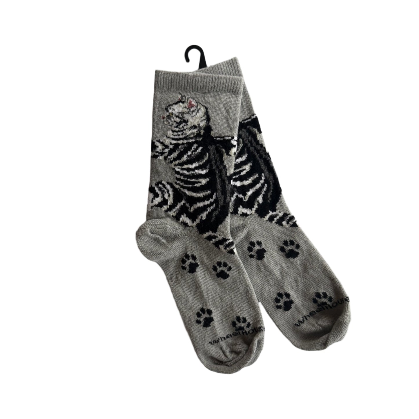 Super cute black & white tiger cat with pink nose and ears and paw prints from the ankle down; light grey background