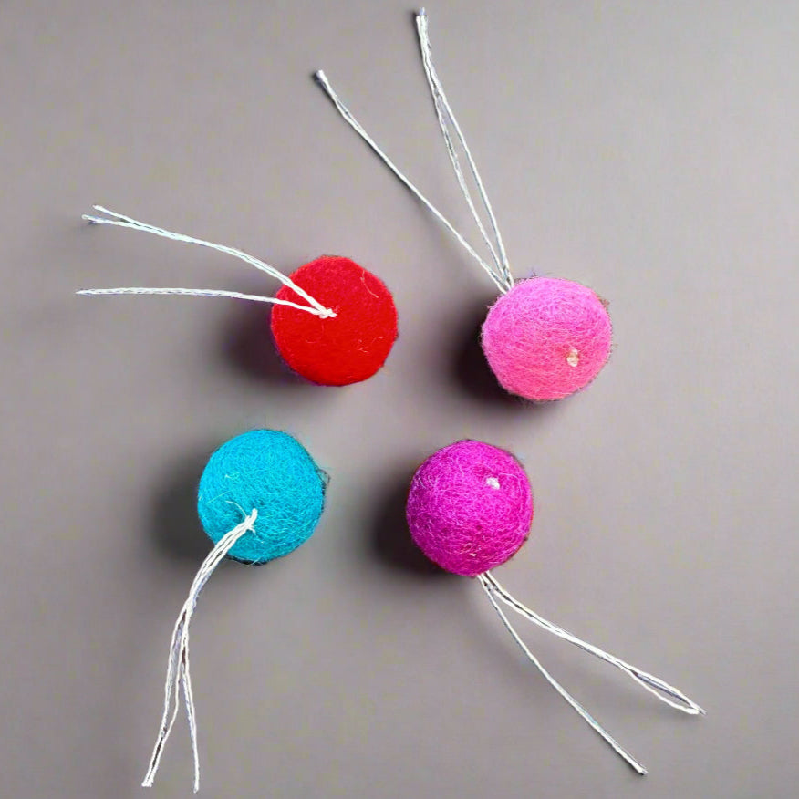 wool balls with thread "tail" are small enough for a cat to pick up with their mouth to carry or toss, just over an inch (2.5 cm) in diameter