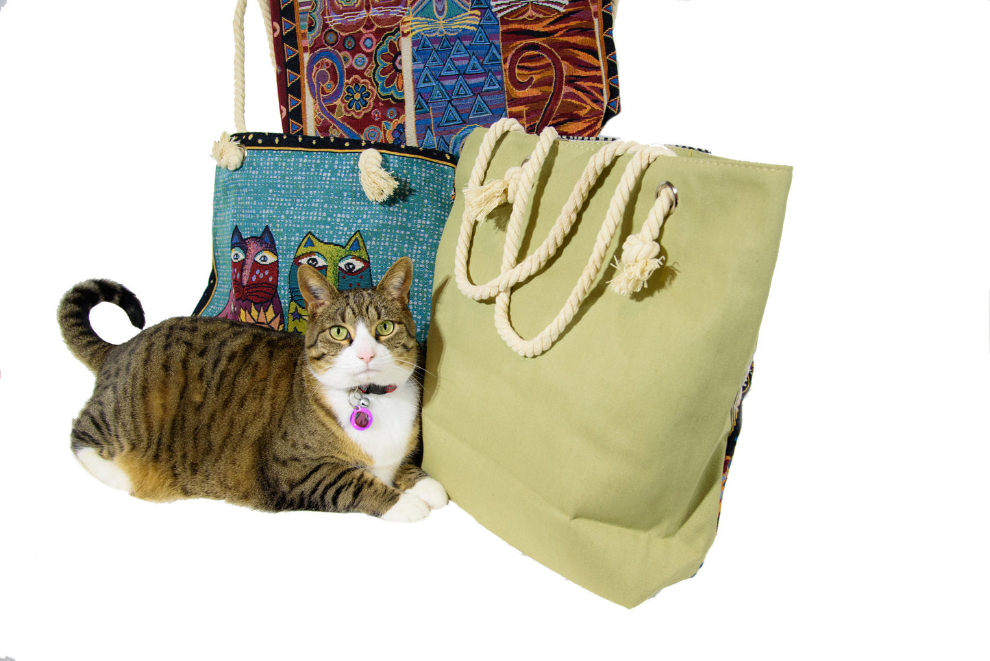 Cute cat in photo (smile)! Iconic Laurel Burch cats on one side, solid red on the other; available in a variety of colours including black, sage green and navy. Sturdy and well-made with inside pocket. Measures 17” x 14”.