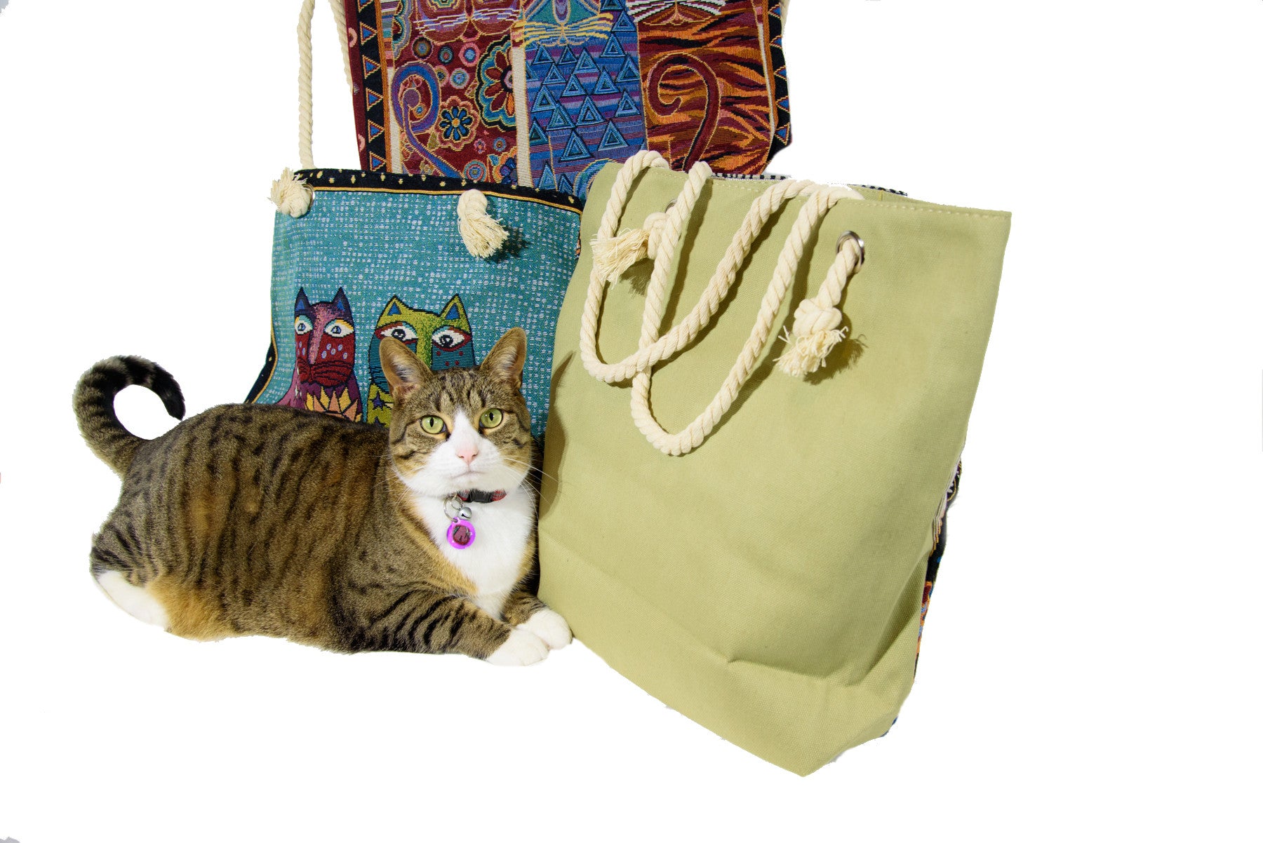 Cute cat in photo (smile)! Iconic Laurel Burch cats on one side, solid red on the other; available in a variety of colours including black, sage green and navy. Sturdy and well-made with inside pocket. Measures 17” x 14”.