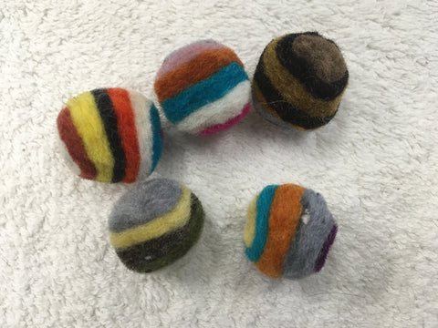 These layered wool balls are small enough for a cat to pick up with their mouth to carry or toss. They also bat them around and chase them. The layers of wool create a striped pattern which makes the ball more visually enticing as it rolls. Many cats have a natural attraction to the scent of wool. The balls are now over an inch (2.5 cm) in diameter, larger than before, and available in bags of 4 or 25.